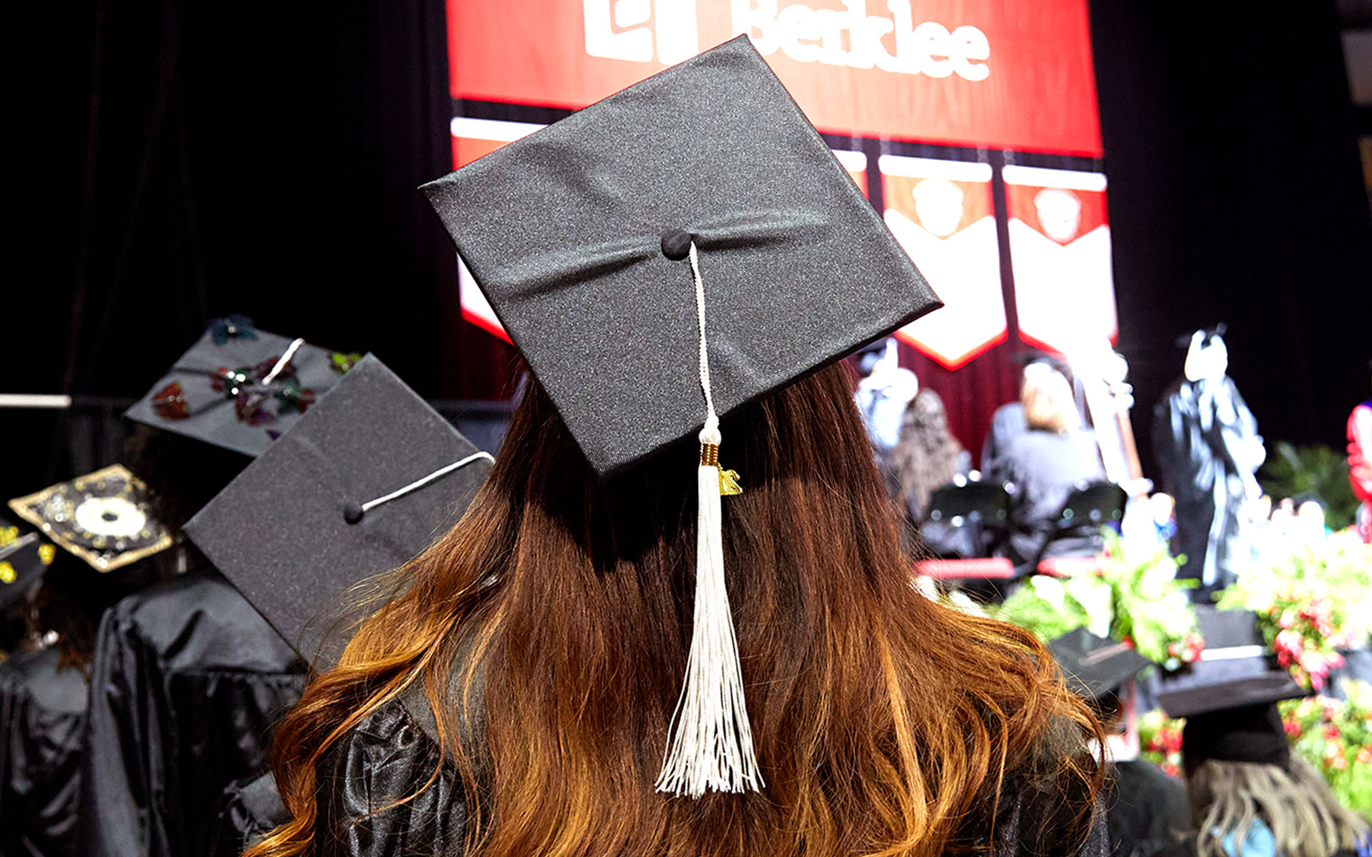 A student is pictured in a cap and gown at the Berklee College of Music Commencement ceremony.